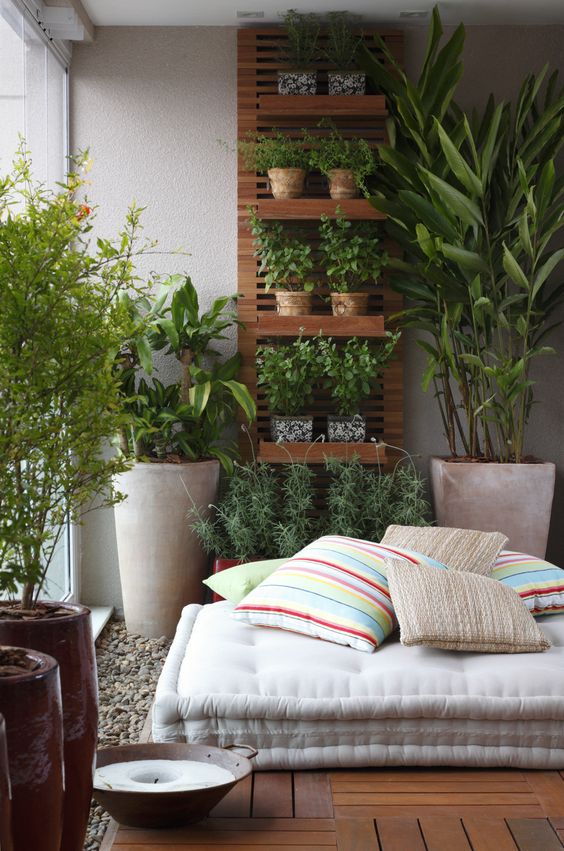 Espaço zen com horta vertical e piso de madeira.